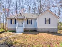 Charming single-story home featuring blue shutters and a well-maintained front yard at 150 Grove Creek Dr, Locust Grove, GA 30248