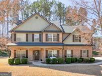 Charming two-story home boasts a welcoming porch, brick accents, manicured shrubs, and a well-maintained lawn at 427 Oscar Ct, Mcdonough, GA 30252