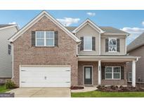 Charming two-story brick home features a two-car garage, neutral colors, and professionally landscaped yard at 604 Clark Lake Estates Dr, Grayson, GA 30017