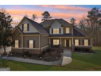Charming two-story home with a combination of stone and siding, with a covered porch, and manicured landscaping at 283 Rosebay Ln, Sharpsburg, GA 30277