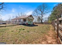Charming country home with red shutters, a metal roof, and a fenced yard at 5700 Mount Zion Rd, Waco, GA 30182
