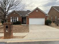Charming brick home featuring an attached two-car garage and well-maintained front yard at 8537 Spivey Village Trl, Jonesboro, GA 30236