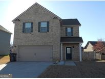 Two-story brick home featuring an attached garage and dark green shutters at 620 Calvo Run, Mcdonough, GA 30253