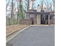 Exterior view of home with covered parking area and landscaped front yard at 26 Cobblestone Crk, Peachtree City, GA 30269