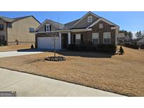 Charming one-story brick home featuring an attached garage, manicured landscaping, and a well-maintained front yard at 912 Nandina Ln, Loganville, GA 30052