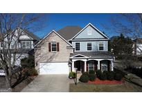 Charming two-story home with manicured landscaping, a covered porch, and a two-car garage at 312 Villa Place Ct, Tucker, GA 30084