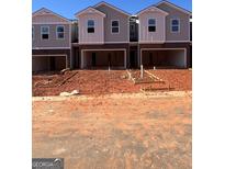 New townhomes show open garages, brown brick and gray siding at 11559 Kimberly Way # 21, Hampton, GA 30228