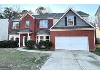 Charming two-story brick home with a well-maintained lawn and a two-car garage, offering great curb appeal at 6159 Sable Fox Dr, Riverdale, GA 30296