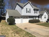 Charming two-story home with a two-car garage and traditional siding and landscaping at 1574 Elizabeth Ln, Hampton, GA 30228