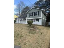 Two story home featuring light green and white paint, a yard, and a covered porch with white columns at 3730 Leisure Lane, Atlanta, GA 30349