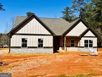 Charming single-story home featuring stone accents, vertical siding, dark trim, and a gray shingle roof at 8088 Lakeview Pkwy, Villa Rica, GA 30180