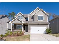 Charming two-story home with attached two car garage, beautiful landscaping and covered front porch at 7754 Hansel Ln, Lithonia, GA 30058