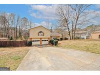 Charming split-level home featuring an attached two-car garage and a spacious driveway at 4161 Windermere Dr, Lithonia, GA 30038