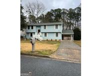 Charming two-story home with light blue siding, white trim, and a well-maintained front yard at 5865 Vernier Dr, Atlanta, GA 30349