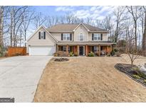 Charming two-story home featuring a welcoming front porch with brick accents and a spacious front yard at 4006 Asheville Ct, Buford, GA 30519