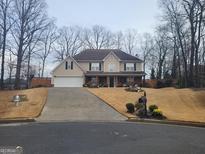 Charming two-story home featuring a manicured lawn, inviting entrance, and attached two-car garage at 4006 Asheville Ct, Buford, GA 30519