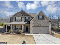 Charming two-story brick home featuring an attached two car garage and landscaped front yard at 10736 Southwood Dr, Hampton, GA 30228