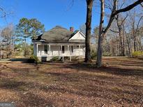 Charming single-story home featuring a cozy front porch and a well-maintained yard with mature trees at 2680 Noahs Ark Rd, Jonesboro, GA 30236