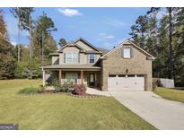 Charming two-story home featuring a two-car garage, landscaped yard, and a welcoming front porch at 540 Deadwood Trl, Locust Grove, GA 30248