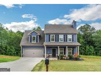 Charming two-story home with blue siding, a well-manicured lawn, and an attached garage with lovely curb appeal at 275 Bramble Bush Trl, Covington, GA 30014