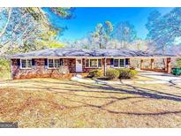 Charming brick ranch home with large front yard, carport, and inviting entrance at 1650 Seayes Sw Rd, Mableton, GA 30126
