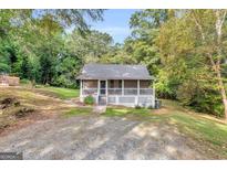 Charming single-story home with a inviting screened porch and lush green surroundings at 4481 Mclain Cir, Acworth, GA 30101