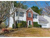 Charming two-story home with white siding, brick accents, and a well-maintained lawn and a two car garage at 762 Simon Park Cir, Lawrenceville, GA 30045