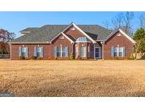 Charming brick home featuring a well-manicured lawn and a gray shingled roof on a sunny day at 263 Caitlyn Dr, Hampton, GA 30228
