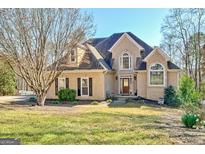 Charming two-story home featuring arched windows, a manicured lawn, and an inviting front entrance at 417 Plantain Ter, Peachtree City, GA 30269