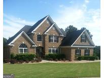 Charming two-story brick home with well-manicured lawn, mature landscaping, and classic architectural details at 3801 Gold Leaf Ct, Stockbridge, GA 30281