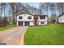 Charming home featuring a well-manicured lawn, updated exterior, and a bright red front door at 7012 Winter Woods Ct, Morrow, GA 30260