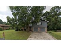 Two-story home with an attached two car garage and mature landscaping at 6861 Wendy Jean Dr, Morrow, GA 30260