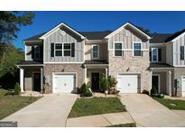 Charming townhome exterior with a well-manicured lawn, front-entry garage, and inviting curb appeal at 142 Hampton Cir, Mcdonough, GA 30253