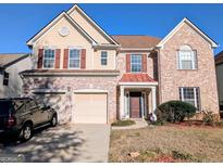 Inviting two-story brick home with a well-manicured lawn and a two-car garage at 5625 Jamerson Dr, South Fulton, GA 30349