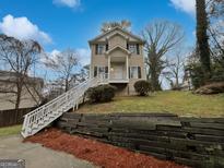 Charming two-story home featuring a white staircase, black shutters, and manicured front yard at 483 Fairlane Nw Cir, Atlanta, GA 30331