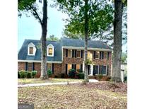 Charming two-story brick home with mature trees and well-maintained landscaping at 105 Windridge Dr, Fayetteville, GA 30215