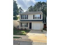 Traditional two-story home with a garage and neutral-toned siding offers great curb appeal at 187 London Dr, Mcdonough, GA 30253