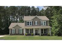 Charming two-story home with a well-manicured lawn and inviting front porch with stone accents at 85 Crabapple Ridge Dr, Oxford, GA 30054