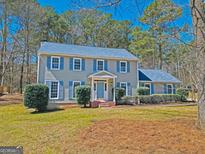 Charming two-story home with light-grey siding, blue shutters, and a well-manicured front lawn at 175 Ashley Dr, Fayetteville, GA 30214