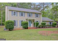 Charming two-story home with blue shutters, a well-manicured lawn, and a welcoming front entrance at 175 Ashley Dr, Fayetteville, GA 30214