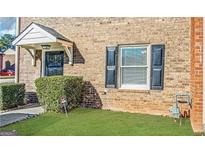 Charming brick townhome featuring a covered entrance and manicured lawn at 4517 Golf Vista Cir, Decatur, GA 30035