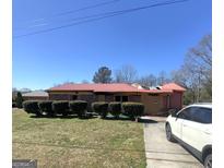 Ranch style home, brick exterior, boarded windows, and red roof on an expansive lot at 329 Oak Dr, Social Circle, GA 30025