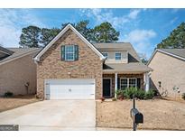 Charming two-story brick home with a well-manicured lawn and an attached two-car garage at 220 Long Dr, Mcdonough, GA 30253