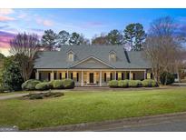 Traditional home boasting symmetrical design, dormer windows, dark shutters and meticulously maintained landscaping at 122 Lawn Market, Sharpsburg, GA 30277
