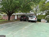 Charming brick ranch-style home with a spacious driveway and mature trees, offering a serene setting at 6826 Mayo Dr, Riverdale, GA 30274
