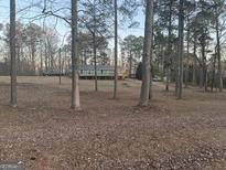 Charming single-level home with a deck, surrounded by a wooded landscape, sitting away from the road at 4864 Yeagar Rd, Douglasville, GA 30135