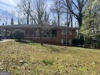 Cozy brick home featuring a covered parking area and a quaint front porch at 2333 Oakridge Ct, Decatur, GA 30032