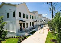 Row of stylish white townhomes with black-framed windows and iron railings, set along a well-manicured street at 2443 Sycamore Nw Rd, Atlanta, GA 30318
