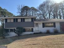Two-story home featuring a brick and gray exterior with black shutters and a well-maintained lawn at 975 King James Dr, Morrow, GA 30260