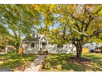 Charming home with beautiful foliage, a welcoming entryway and well-maintained lawn at 1471 Hardin Ave, College Park, GA 30337